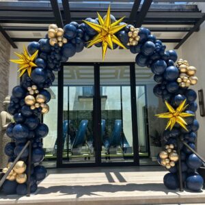 The Balloon Arch features navy blue and gold balloons with three large gold star accents, expertly designed and displayed in front of glass double doors—an ideal centerpiece for any corporate event.