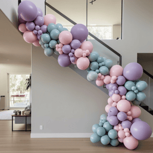 The Balloon Garland in pastel pink, purple, and blue adds a bright touch to a modern Los Angeles staircase—ideal for stylish corporate events.