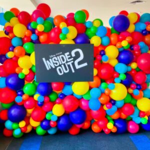 The Balloon Wall features vibrant balloon decor and a rectangular black sign with "Disney Pixar Inside Out 2" in white letters.