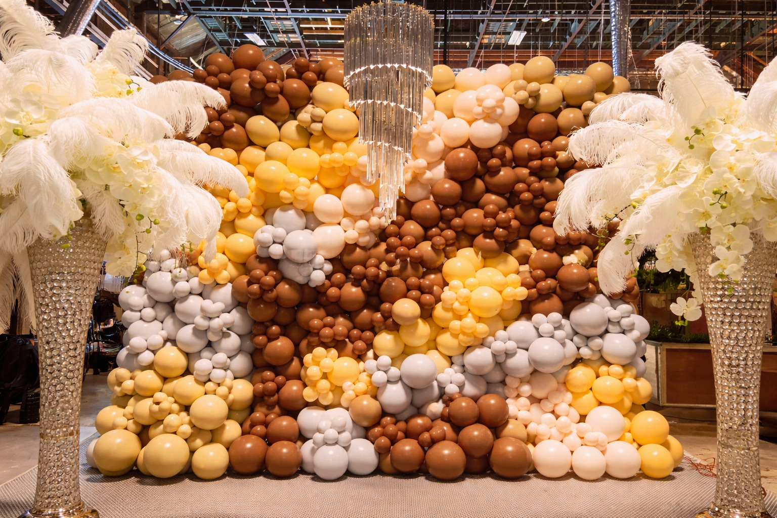 Luxury organic balloon wall with chandelier and feather arrangements designed by The Balloon Guy for an event in Los Angeles