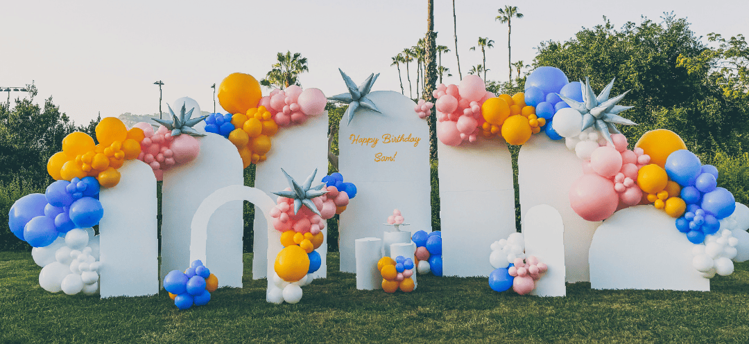 A bunch of balloons are sitting on top of a lush green field.