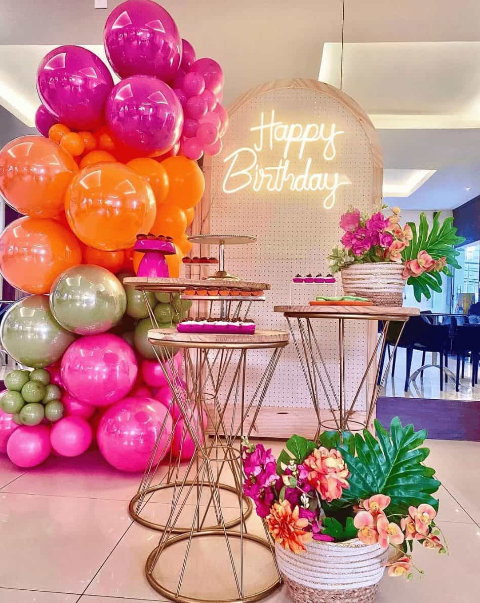 A room decorated with balloons and flowers for a birthday party.
